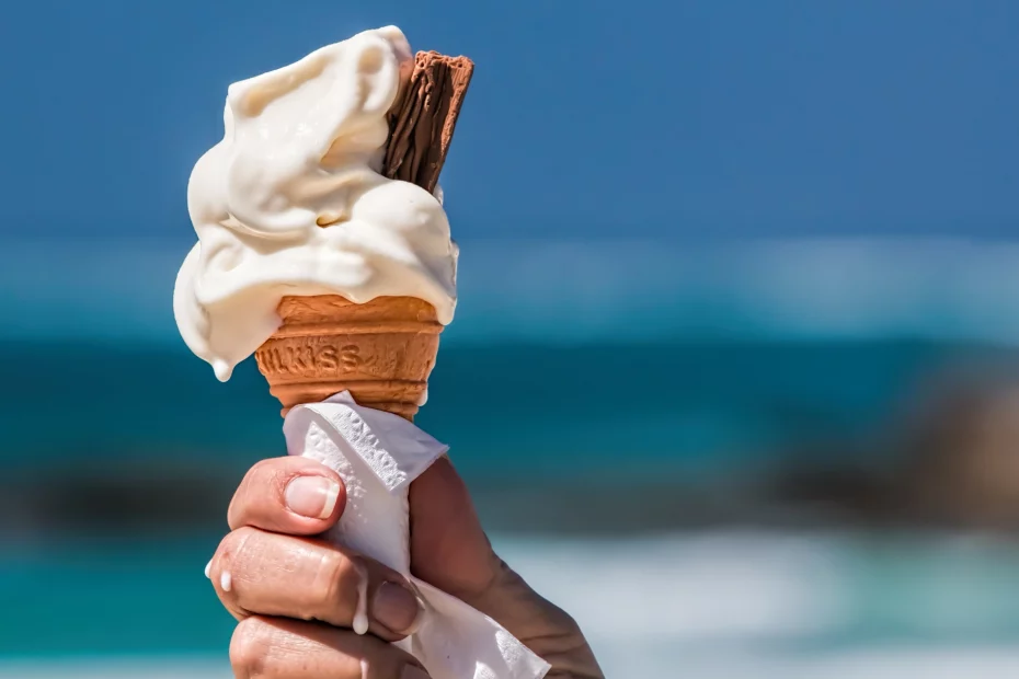 Femme qui tient une glace à la vanille avec du chocolat dessus